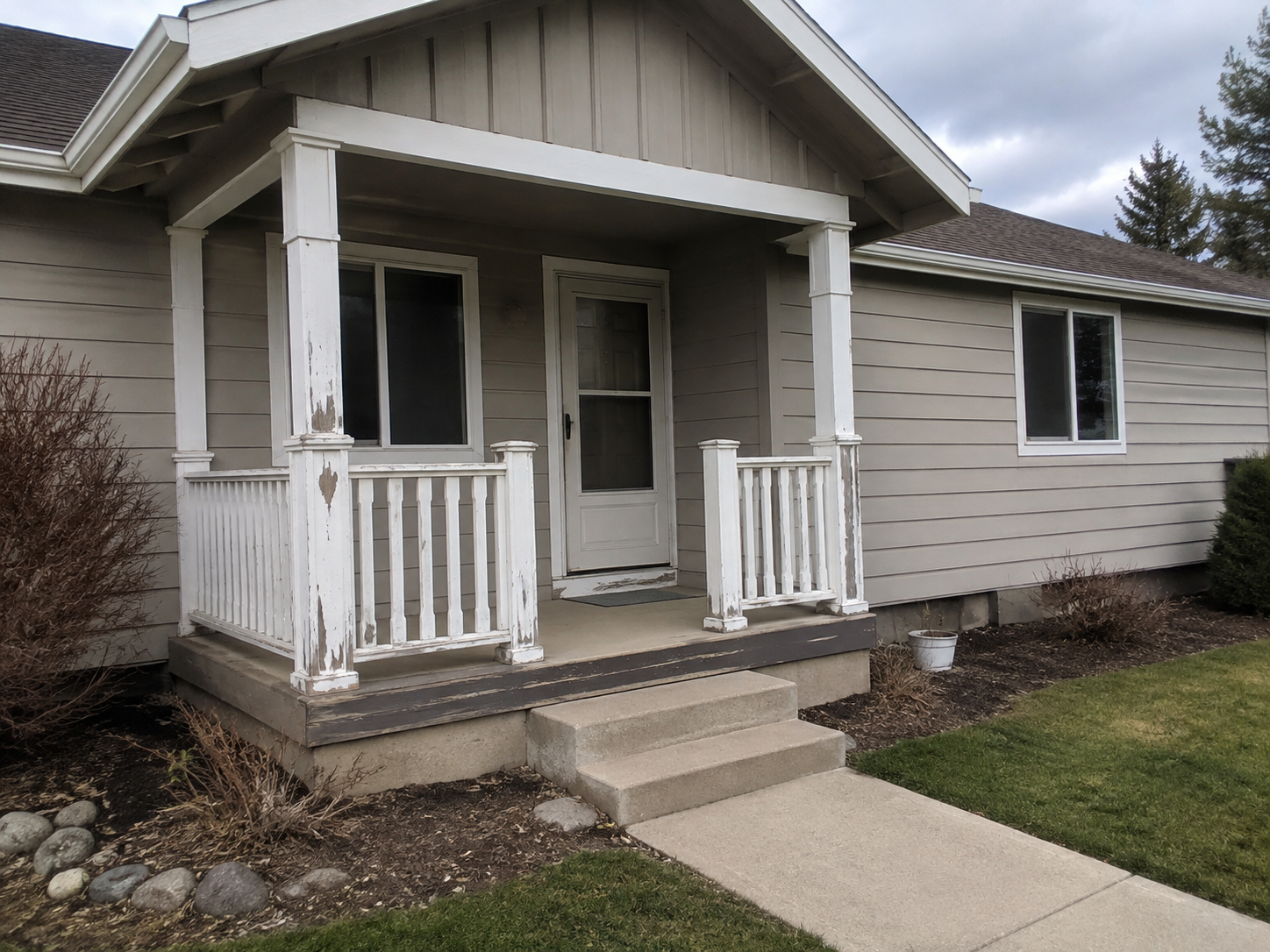 Weathered porch columns and trim with peeling paint